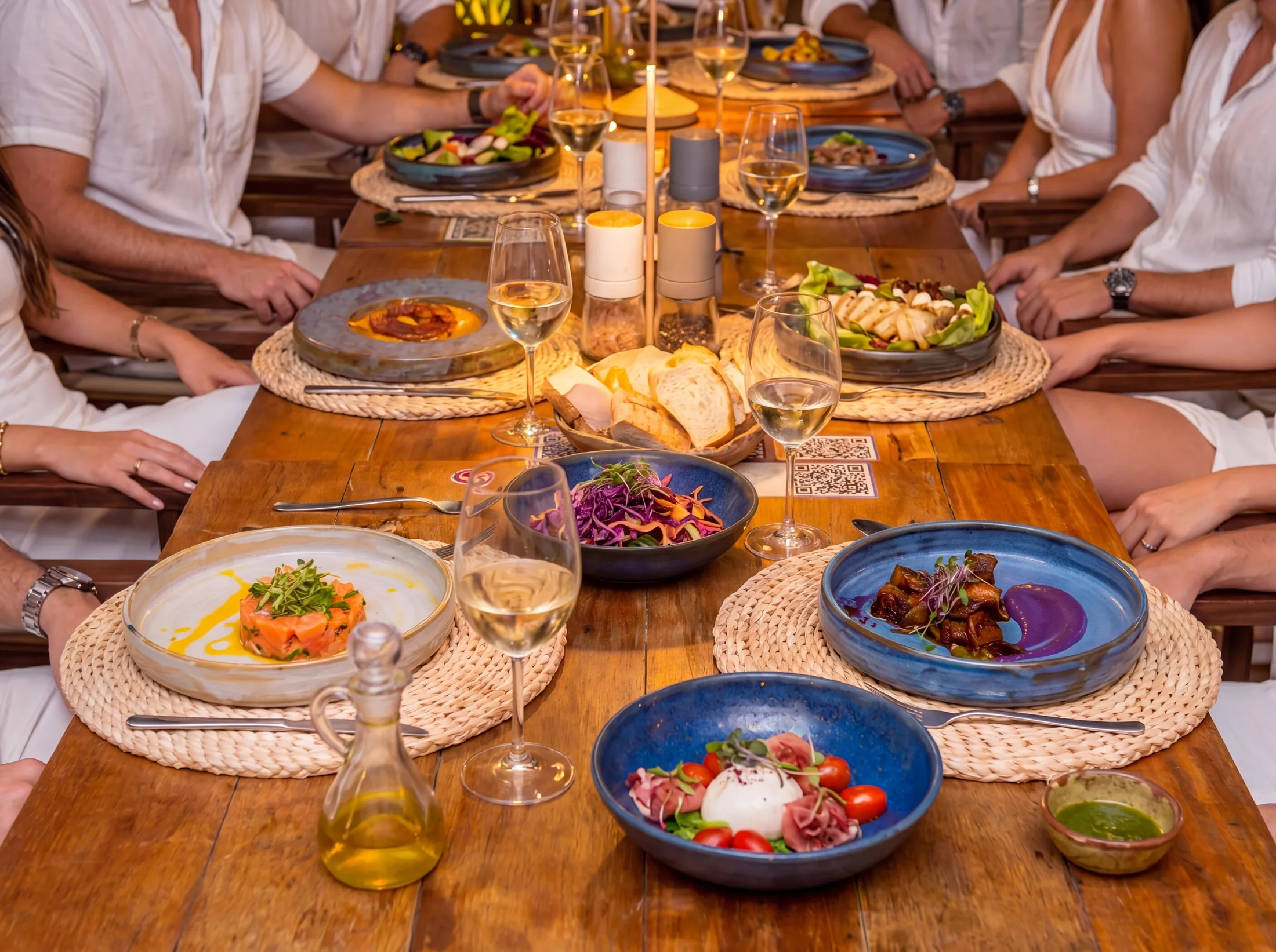 A set table with plated dishes at dusk.